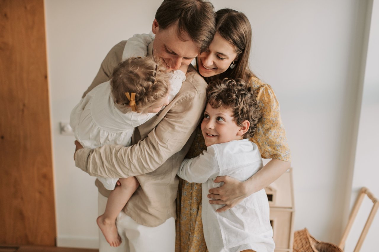 Eine Familie umarmt sich liebevoll in ihrem gemütlichen Zuhause.