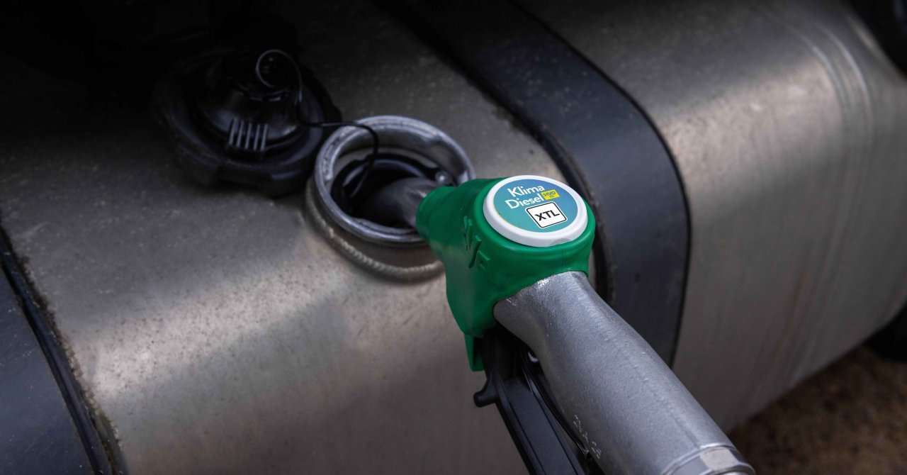 Grüner Zapfhahn mit Aufschrift 'XTL' an Tanköffnung eines Fahrzeugs.