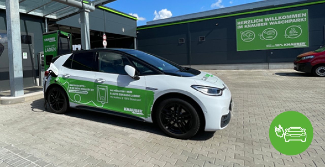 An einer E-Tankstelle steht ein weißes E-Auto.