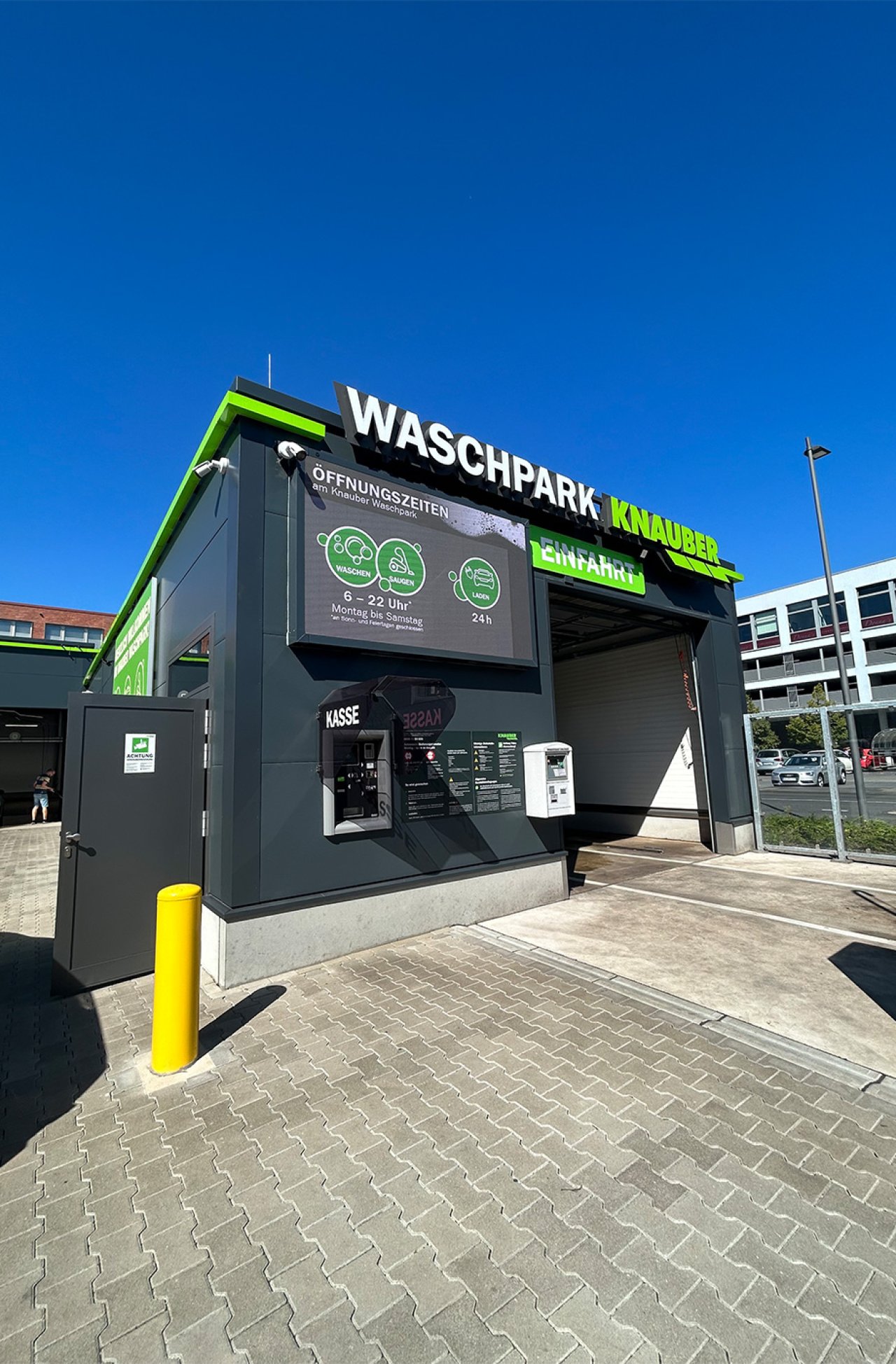 Modernes dunkelgrünes Gebäude des Knauber Waschparks mit der Aufschrift
