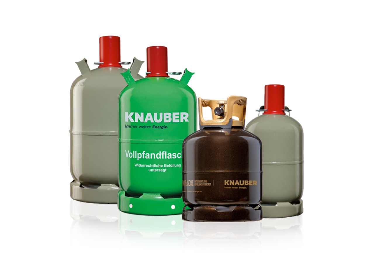 Vier Knauber Gasflaschen, drei graue und eine grüne mit roten Kappen.